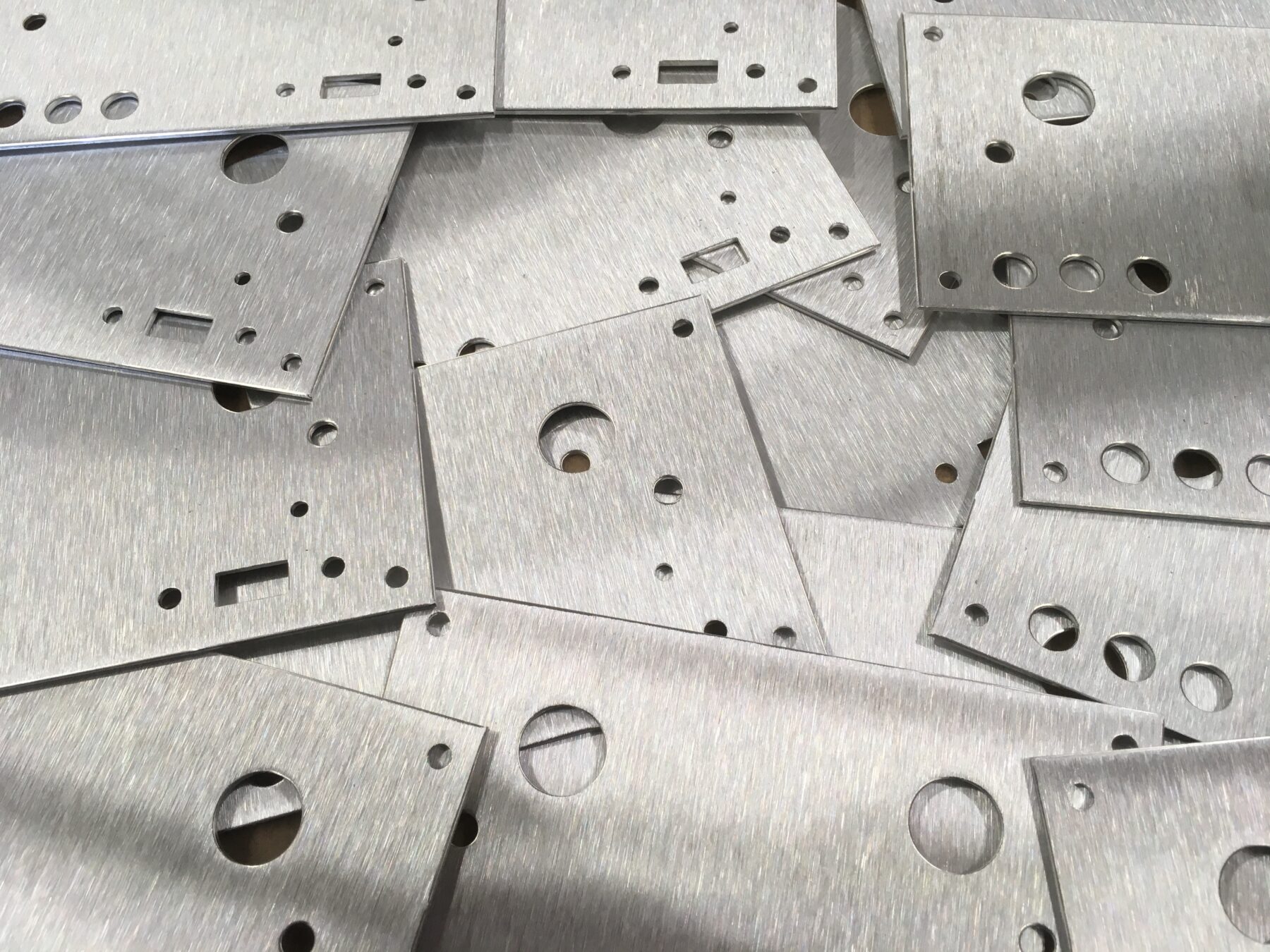 laser cut machined sheet metal front panels with brushed finish and precise internal cutouts